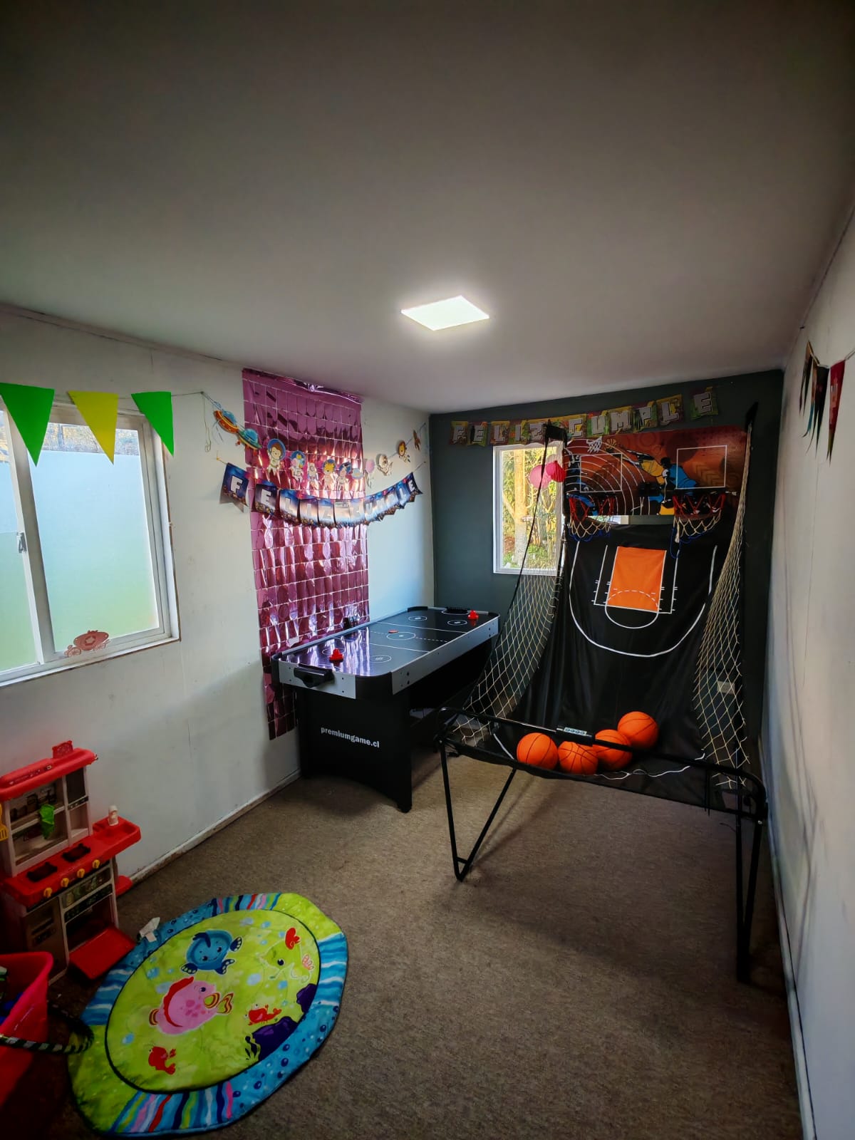 Zona con mesa de air hockey y juego de básquetbol