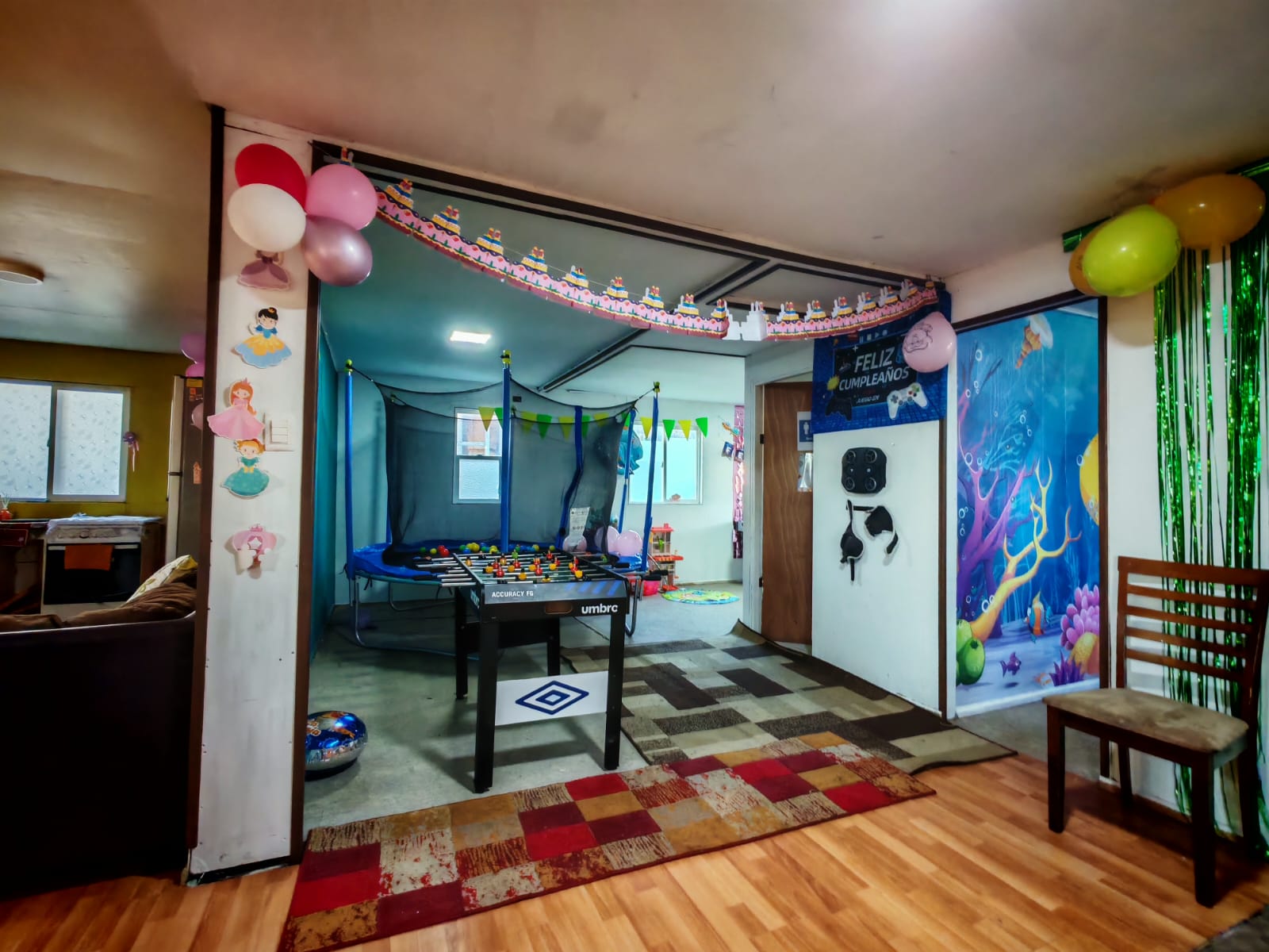 Zona de juegos con taca taca y cama elástica